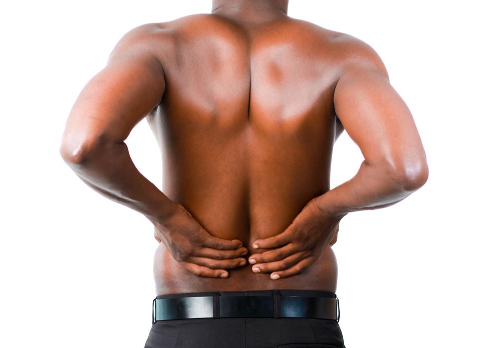 A man feeling lower back pain and in need of a chiropractor adjustment.